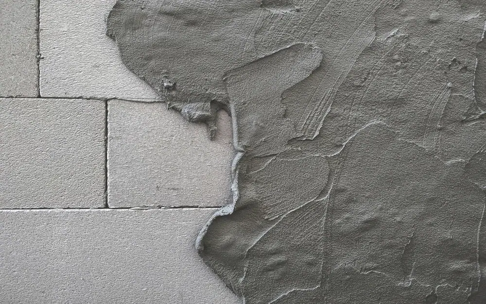 Close-up of a peeling wall texture in Suffolk County, New York, highlighting areas of deterioration and surface damage requiring restoration by Power House Mason Supply